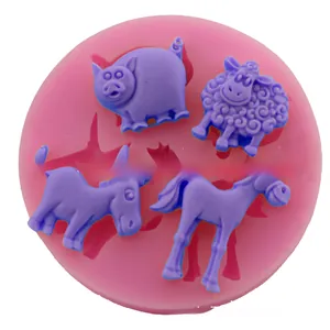 Detail view of pink silicone mold with purple sheep, pig, donkey, and horse cake shapes