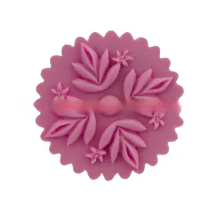 Macro detail of leaf and flower relief patterns inside pink silicone baking mold