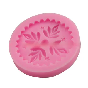 Macro detail of round pink silicone mold featuring intricate leaf and star patterns