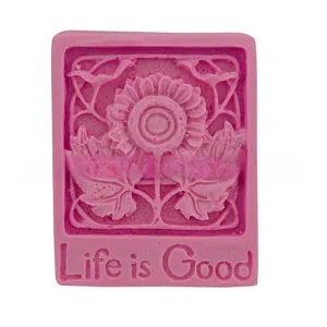 Macro detail of pink silicone mold featuring sunflower relief and Life is Good text engraving