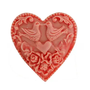 Detail view of pink heart-shaped silicone mold featuring embossed birds and roses pattern
