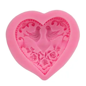 Detail of pink heart-shaped silicone mold with rose flower and bird relief patterns