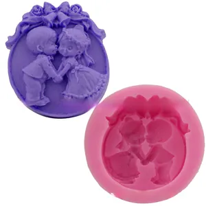 Detail of pink silicone mold with 3D boy and girl fondant relief and floral border