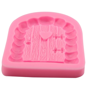Pink silicone mold featuring fairy door design with heart and wood texture for fondant