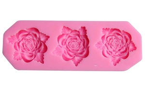 Pink silicone fondant mold featuring three detailed rose flower designs for cake decorating