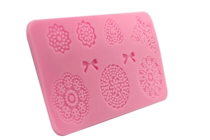 Pink silicone mold featuring detailed embossed butterfly and floral patterns for fondant