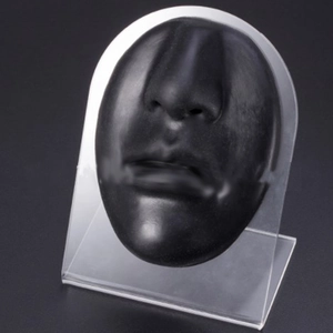 Macro detail of black silicone nose and lip model for PMU practice on acrylic stand