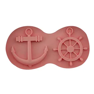 Pink silicone mold featuring nautical anchor and ship wheel shapes for DIY cake decorating