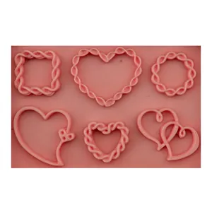 Pink silicone fondant mold with six distinct heart and vine patterns for DIY baking
