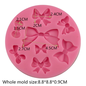 Pink silicone fondant mold with 8 bow-tie shapes for DIY cake decorating and chocolate baking