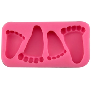 Pink silicone mold featuring four baby footprint designs for fondant and cake decorating