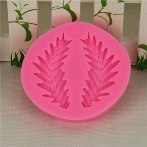 Pink circular silicone mold featuring detailed leaf and feather textures for baking