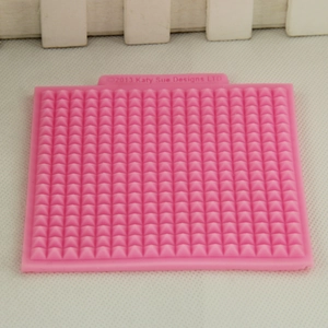 Pink silicone fondant mold with waffle pattern and pyramid texture for cake decorating