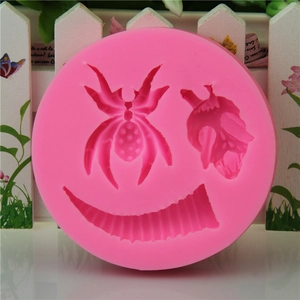 Pink silicone mold featuring spider and insect mask designs for Halloween baking and soap making