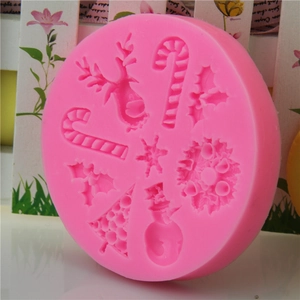 Pink silicone Christmas mold with reindeer, snowman, and tree designs for cake decorating