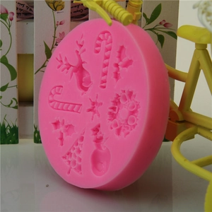 Pink silicone mold featuring Christmas tree, reindeer, and candy cane shapes for DIY baking