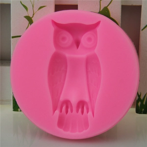 Pink owl silicone mold for DIY baking and handmade soap on white wooden background