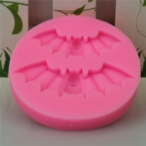 Pink round silicone mold featuring two bat shapes for Halloween cake decorating