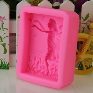 Macro view of a pink silicone mold showing detailed fairy and butterfly floral relief