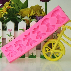 Pink silicone mold featuring 5 detailed cherry bow shapes for DIY baking and chocolate making