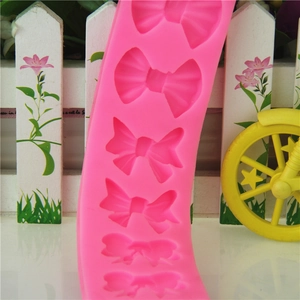 Pink silicone mold featuring 6 cherry bow tie cavities for DIY cake fondant and chocolate