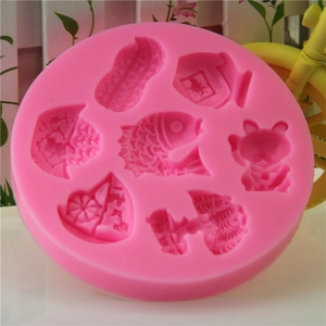 Pink 7-hole silicone mold featuring fish, cat, and flower patterns for DIY baking