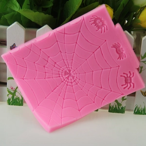Pink silicone fondant mold featuring a detailed Halloween spider web and spider designs