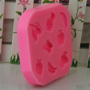 Pink silicone fruit mold featuring strawberry and pineapple shapes for cake decorating