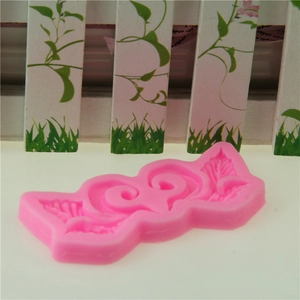 Pink vine silicone fondant mold with intricate leaf and scroll patterns for cake decorating
