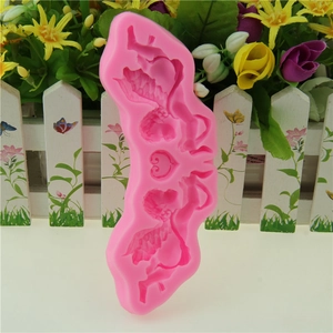 Pink silicone fondant mold featuring symmetrical cupid angel designs for cake decoration