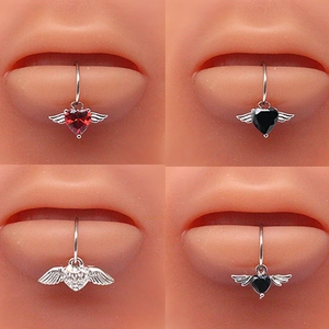 Macro shot of heart shaped angel wing lip rings with red, black and white zircon stones