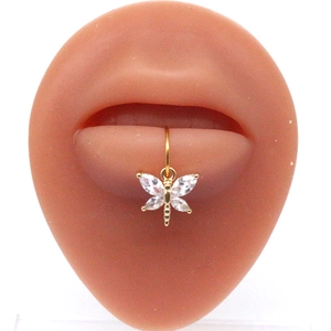 Golden butterfly lip ring with white zircon wings displayed on a silicone lip model
