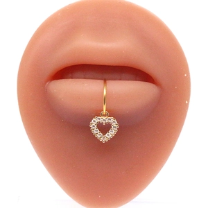 Gold heart-shaped lip ring with white zircon stones on silicone model display
