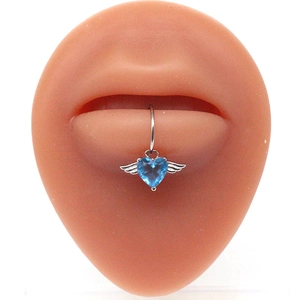 Detail of winged heart lip ring with blue zircon gemstone on silicone model lips