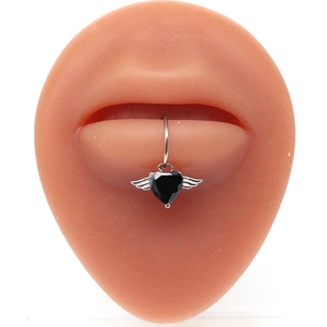 Macro view of a heart-shaped black zircon lip ring with silver wings on a silicone model