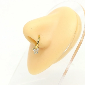Close-up of golden butterfly nose ring with sparkling zircons on a display model