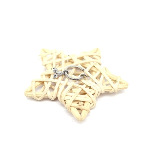Close-up of silver hoop ring with a three-stone zircon flower pendant on woven prop