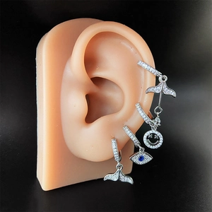 Set di orecchini color argento con ciondoli coda di sirena e malocchio su modello