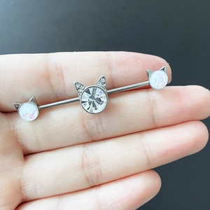 Macro detail of cat-shaped industrial barbell with clear zircon and white opal stones