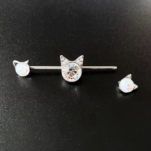 Detailed view of cat-themed industrial barbell with white opal and clear zircon stones