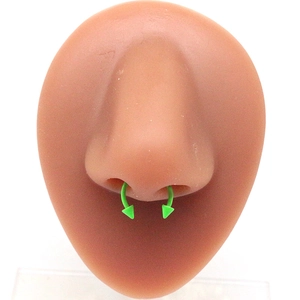 Primo piano di un anello a ferro di cavallo verde neon in acciaio inox con punte a cono