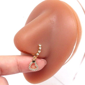 Detailopname van een gouden hartkroon neusring met zirkoon op een siliconen model