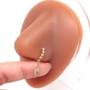 Detail van gouden neusring met sprankelende bliksemhanger op een model