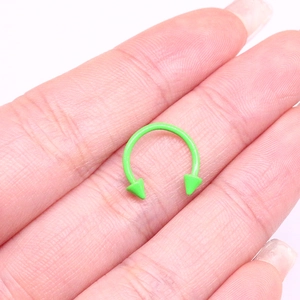 Dettaglio macro di anello a ferro di cavallo in acciaio inossidabile verde acceso
