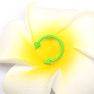 Dettaglio di un piercing a ferro di cavallo in acciaio inossidabile verde neon brillante