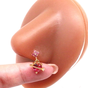 Detail of a gold nose ring with a pink heart gemstone and flower cluster on a model