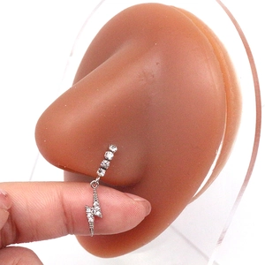 Detailopname van een zilveren bliksem neuspiercing met glanzende zirkonia op model