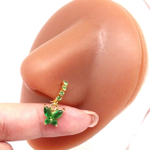 Detailed view of a gold nose ring with green marquise crystal butterfly on a nose model