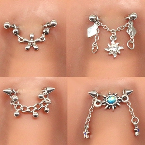 Detail showing four assorted stainless steel eyebrow rings with zircon flower and star charms