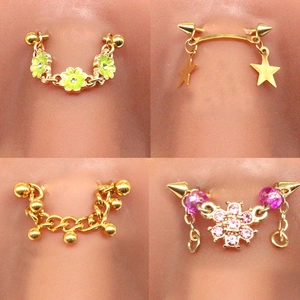 Detail of four gold eyebrow ring designs with floral, star, and chain dangle charms